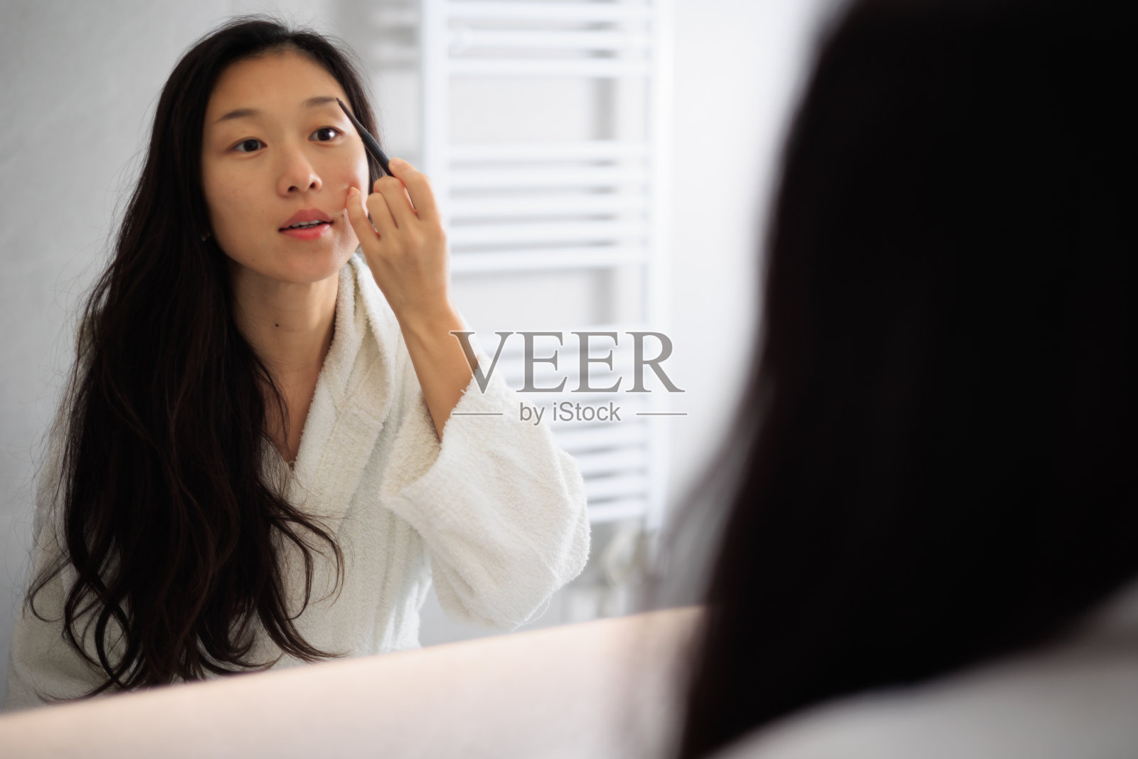 漂亮的年轻亚洲女人正在化妆照片摄影图片