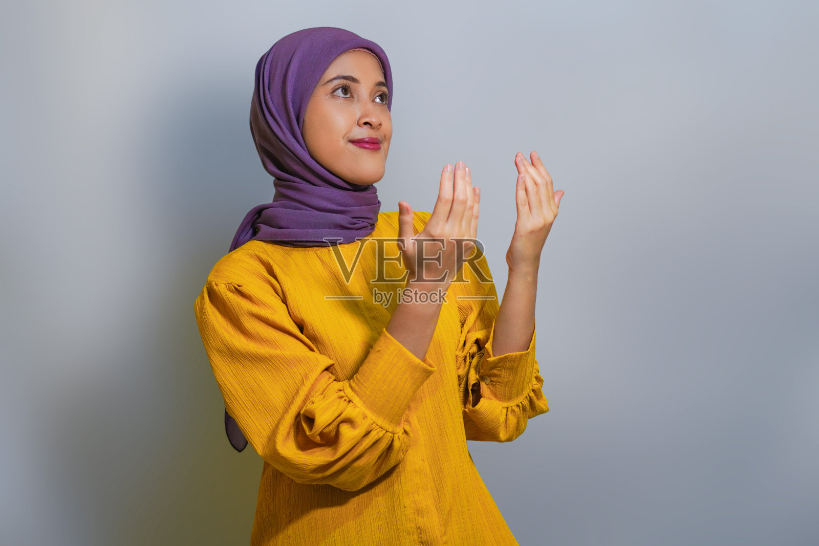 年轻的亚洲穆斯林妇女穿着黄色的衣服,孤立在白色的背景上照片摄影图片