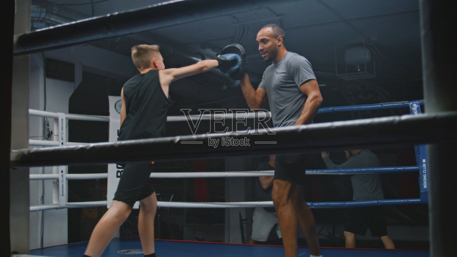 戴着拳击手套的小男孩打拳击手套并练习照片摄影图片