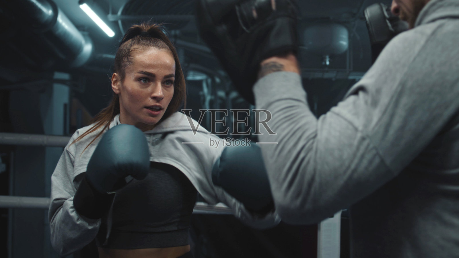 戴着拳击手套练习格斗技巧的女拳击手照片摄影图片