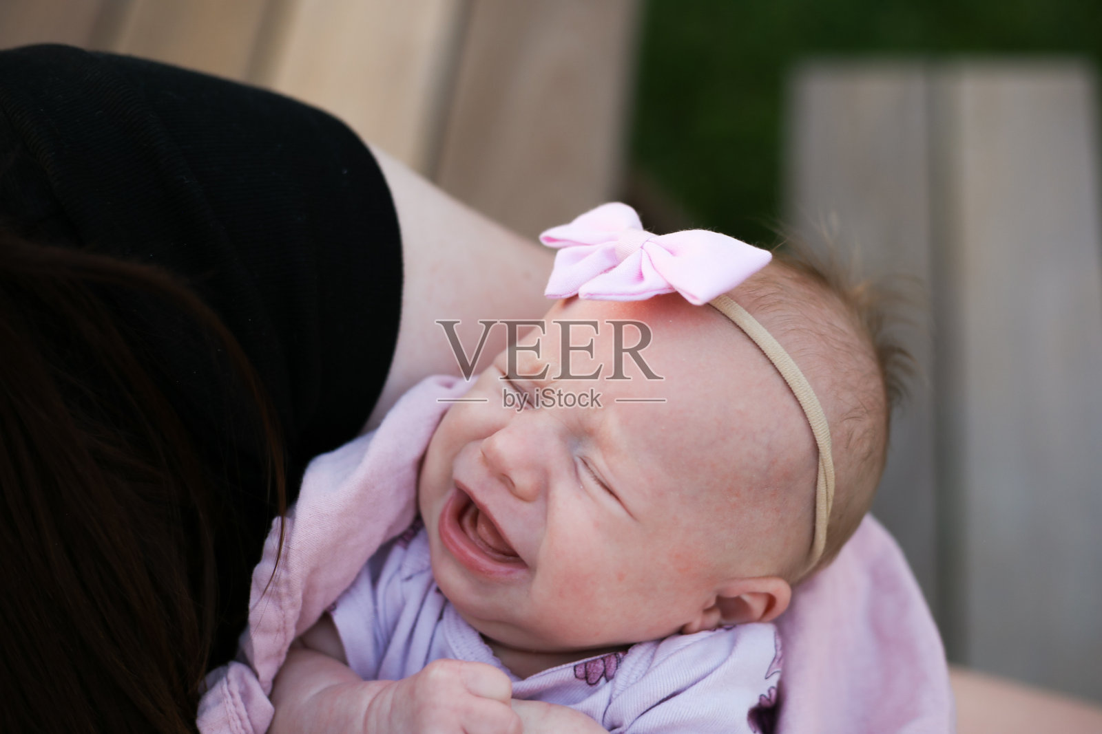 一个刚出生的女婴在母亲怀里哭泣照片摄影图片