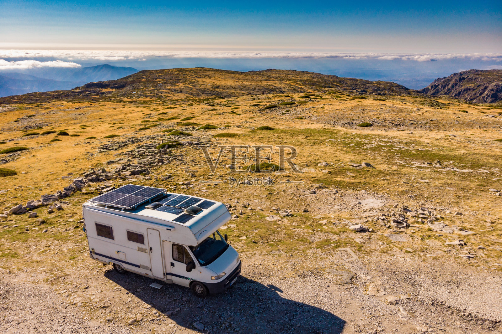 大篷车的屋顶太阳能电池板在山上露营。鸟瞰图照片摄影图片