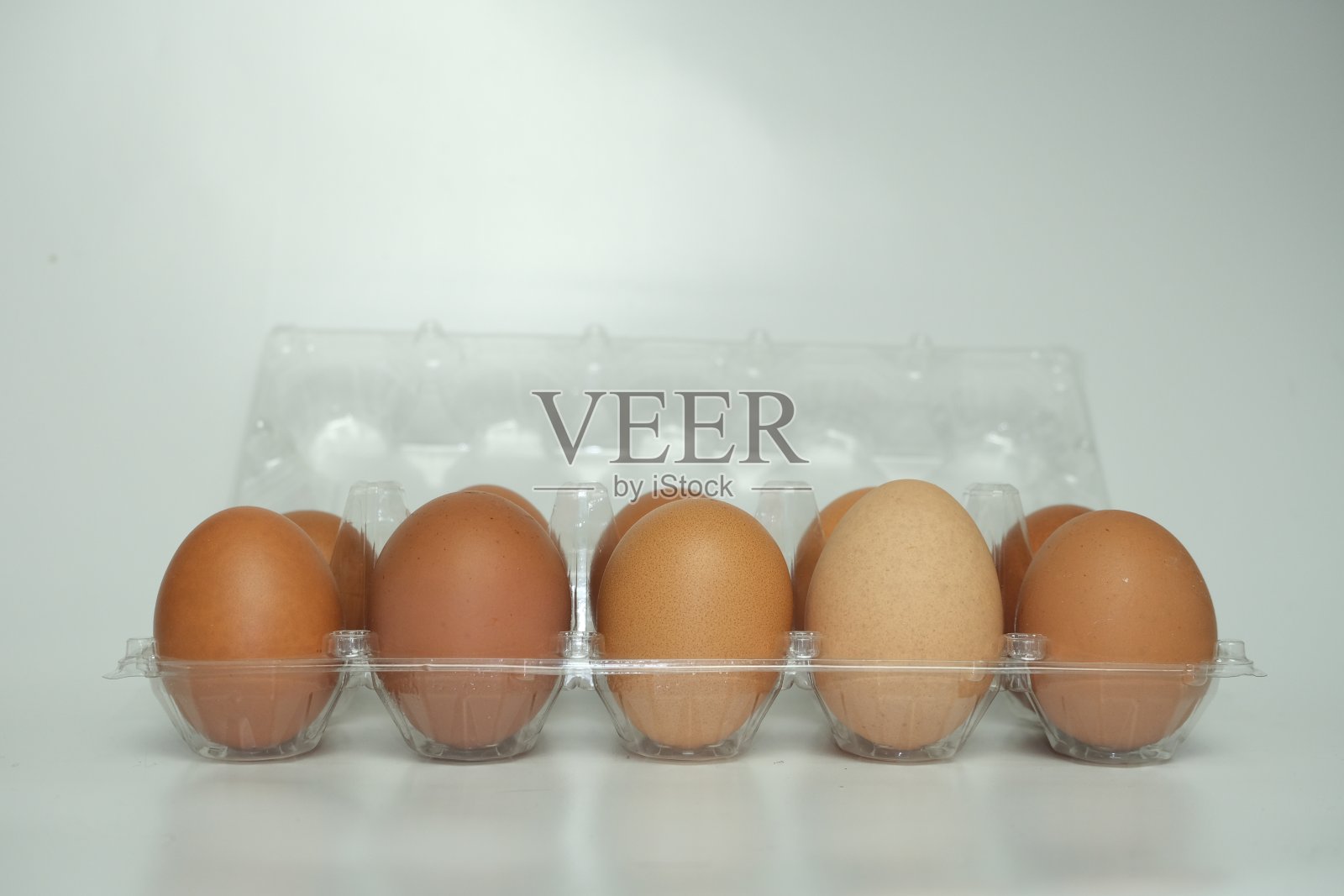 鸡蛋的侧面视图在打开的塑料包装隔离在白色背景照片摄影图片