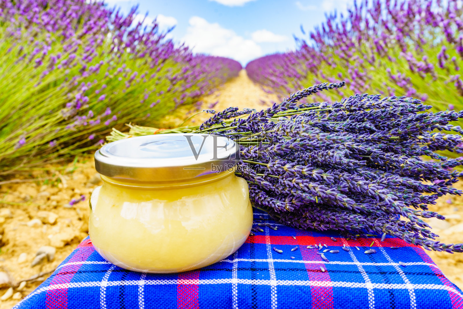 一罐蜂蜜和薰衣草花。照片摄影图片