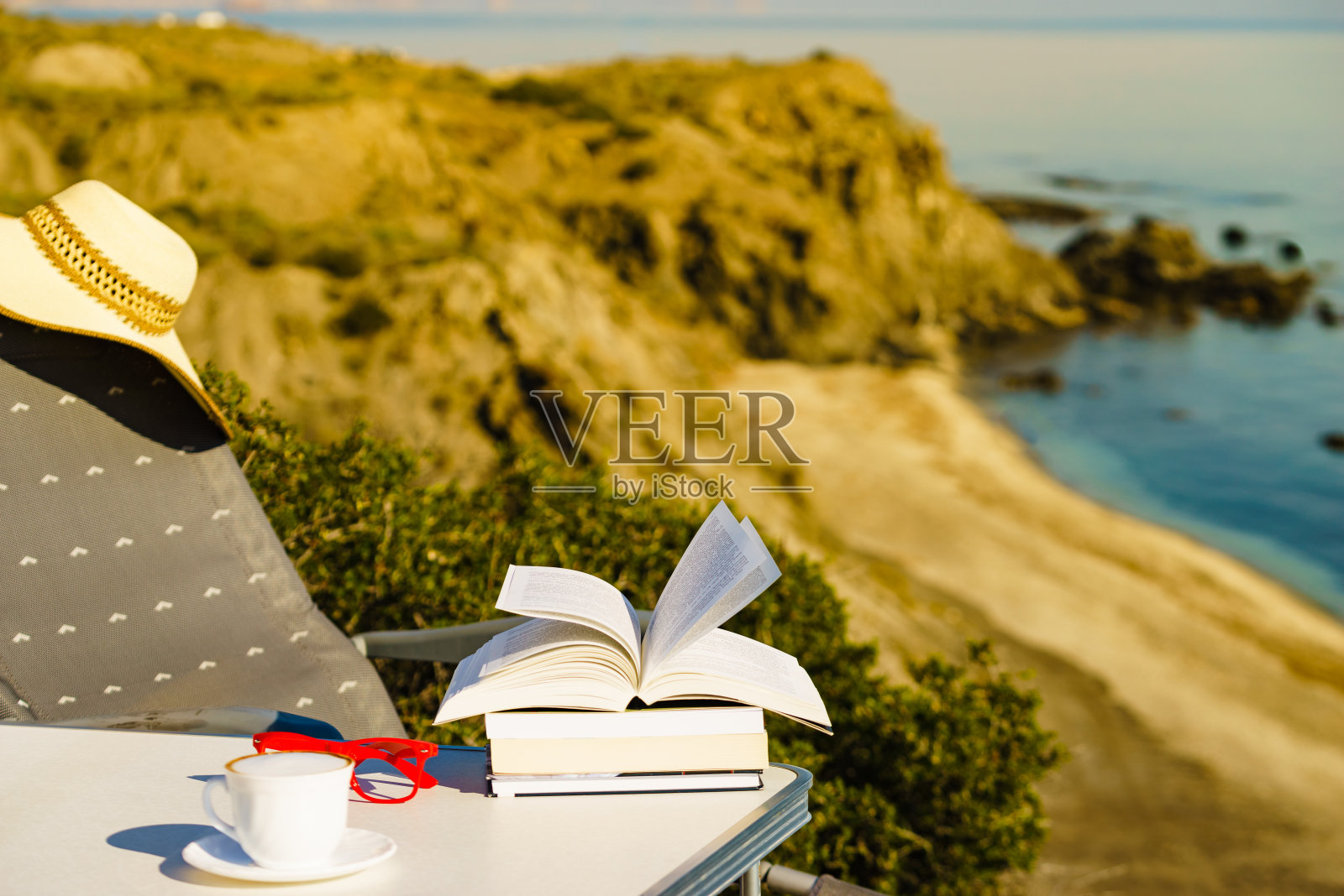 咖啡杯和书在海边。放松照片摄影图片