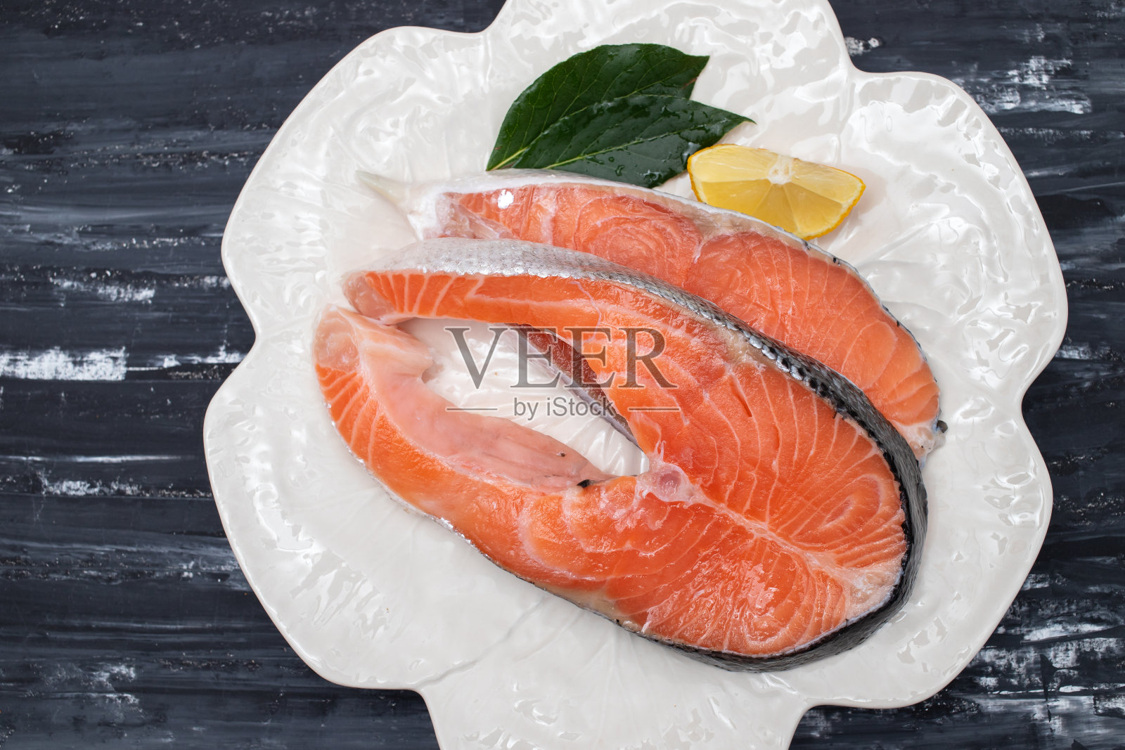 盘子里有一片新鲜的生鲑鱼照片摄影图片