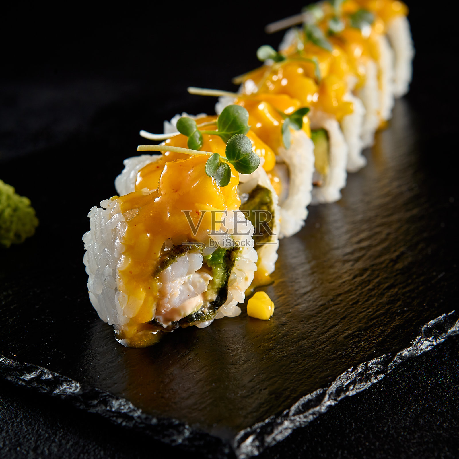 虾寿司卷配芒果塔塔,在黑色石板上提供奢华的展示照片摄影图片