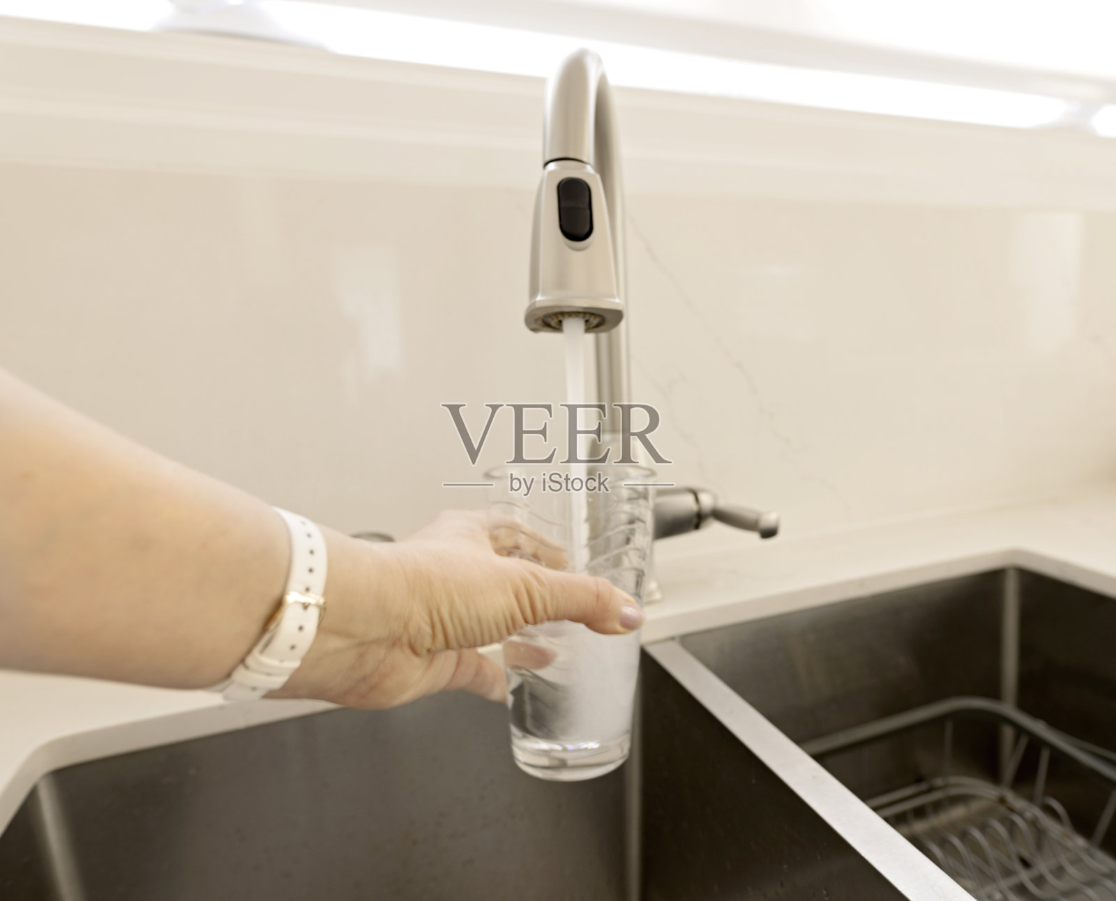 一名妇女正在往自来水里装水照片摄影图片