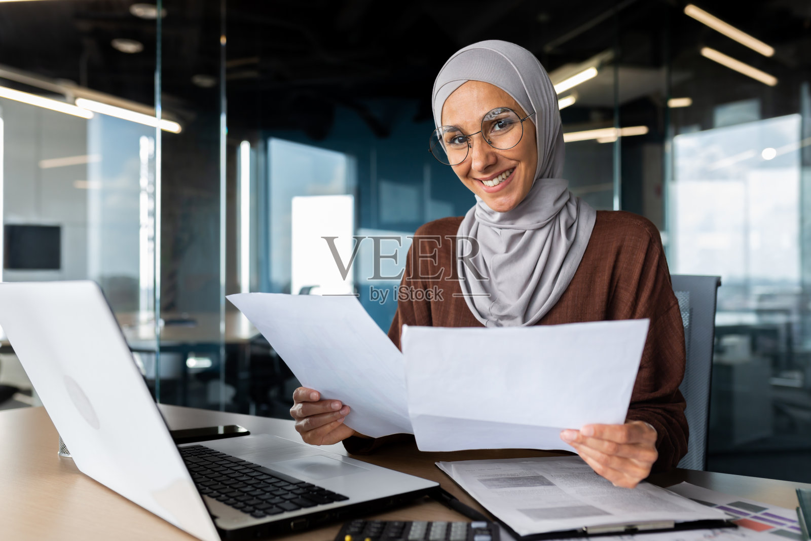 年轻的穆斯林女设计师在办公室使用笔记本电脑工作照片摄影图片