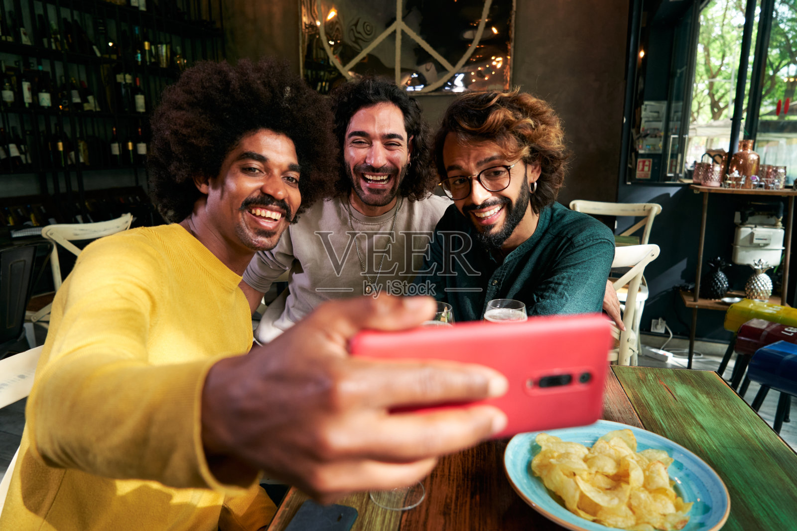 三个男性朋友在酒吧愉快聚会的自拍,用手机拍照。照片摄影图片