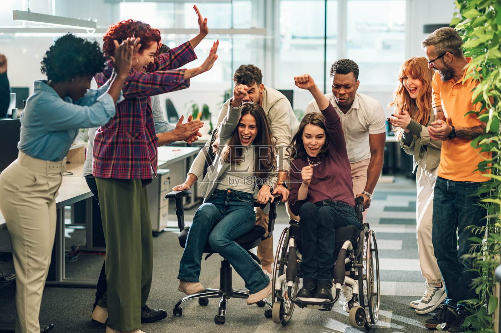 一个多元包容的人在办公室椅子上玩得开心和比赛的肖像照片摄影图片