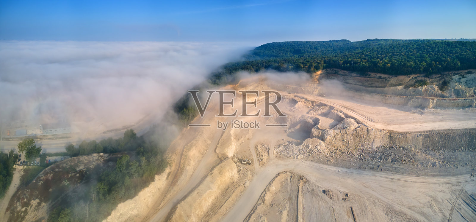 建筑行业用挖掘机和自卸车露天开采石灰石材料鸟瞰图。照片摄影图片