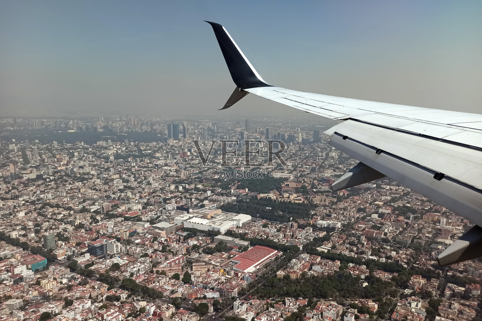 从降落在当地机场的商用喷气式飞机的飞机窗口看墨西哥城。航空旅行概念照片摄影图片