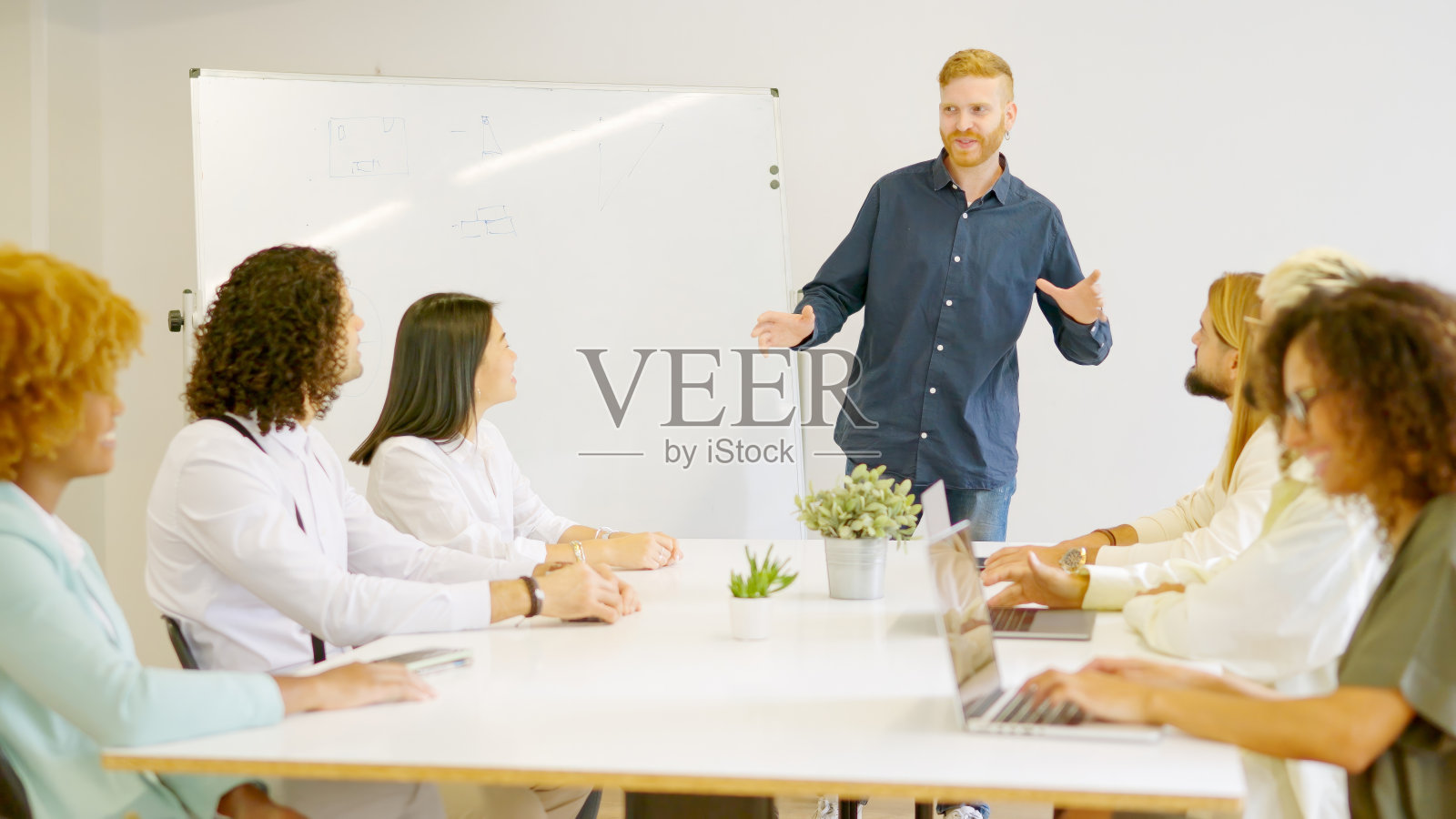 在联合办公场所用板子主持会议的人照片摄影图片