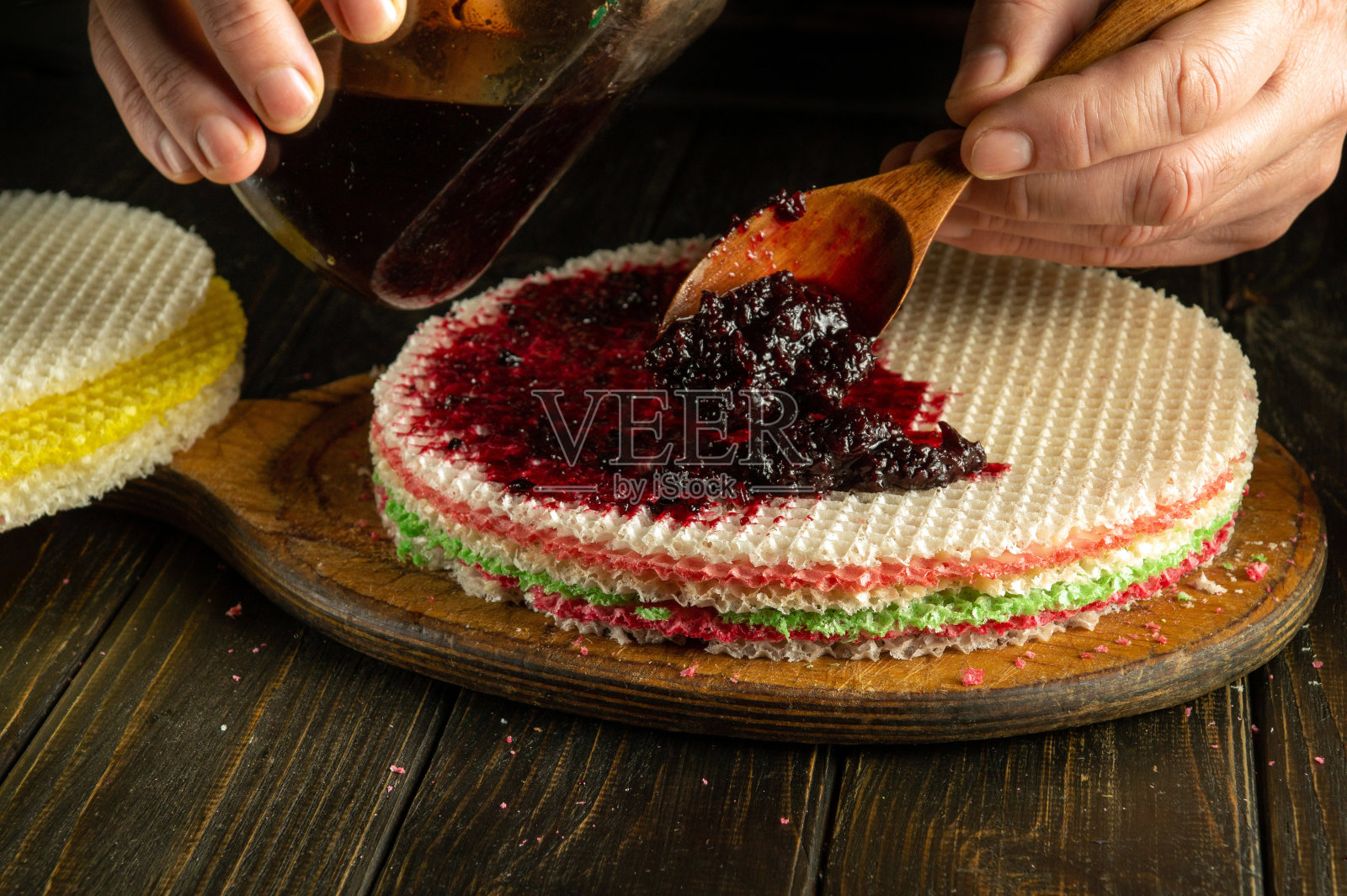 厨师手里拿着果酱勺。为节日餐桌准备华夫饼的过程照片摄影图片