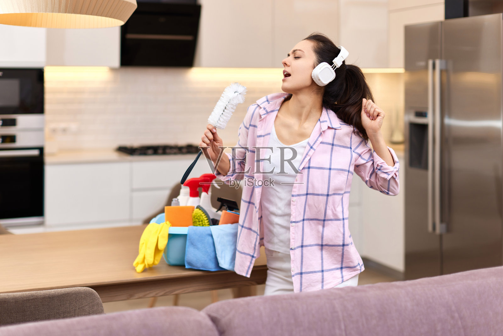 家庭主妇一边唱歌一边打扫房间,照片摄影图片