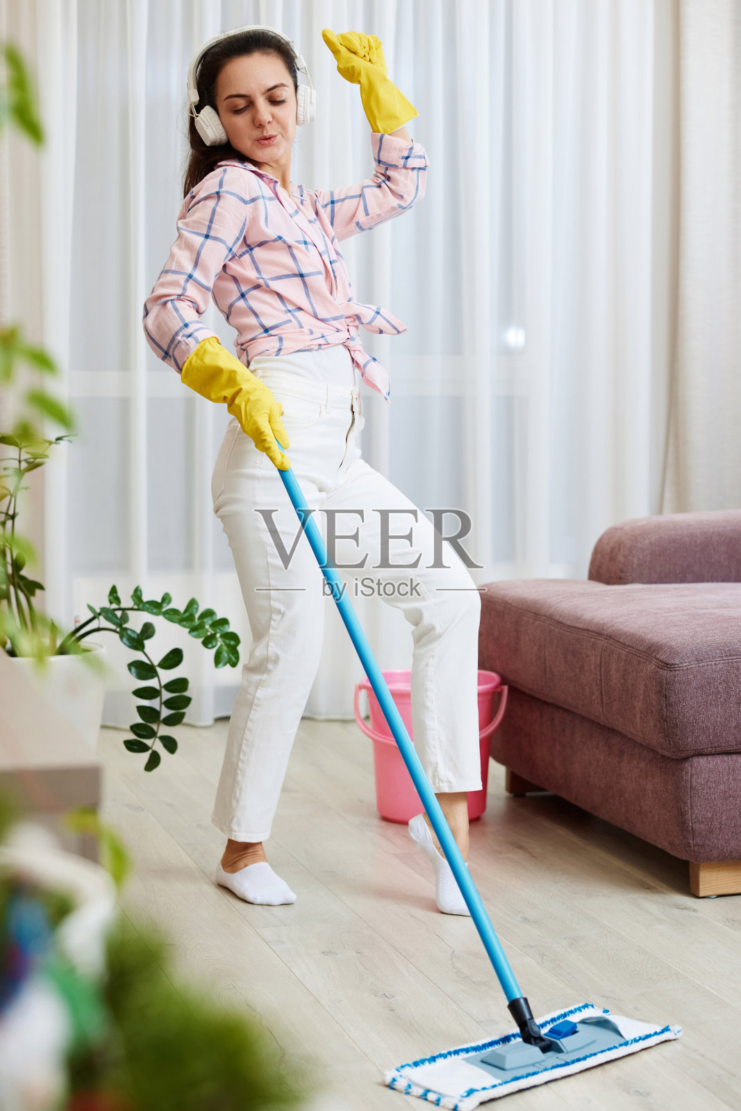 快乐的女人在客厅边唱歌边洗地板照片摄影图片