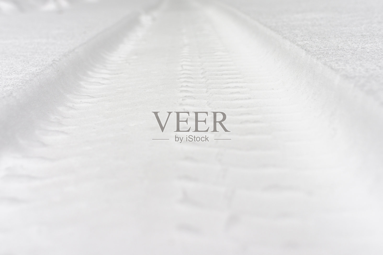 冬天的乡村道路上被雪覆盖的轮胎印。特写,复制空间。照片摄影图片