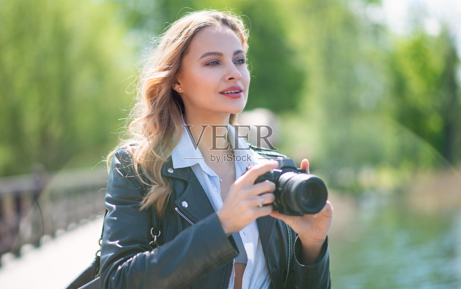 一个女人在公园里用她的数码相机照片摄影图片