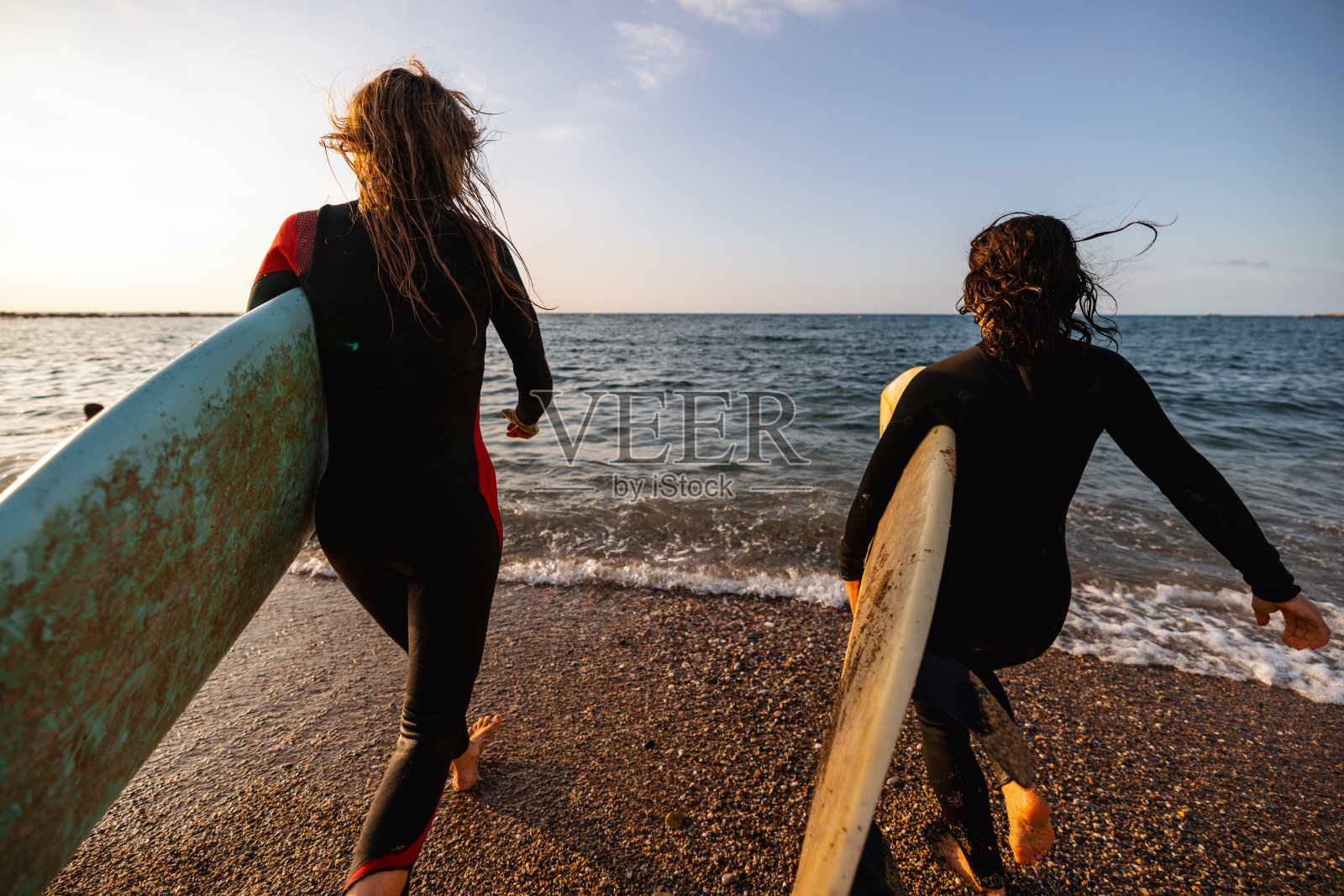 两个女冲浪者朋友跑到水里冲浪照片摄影图片