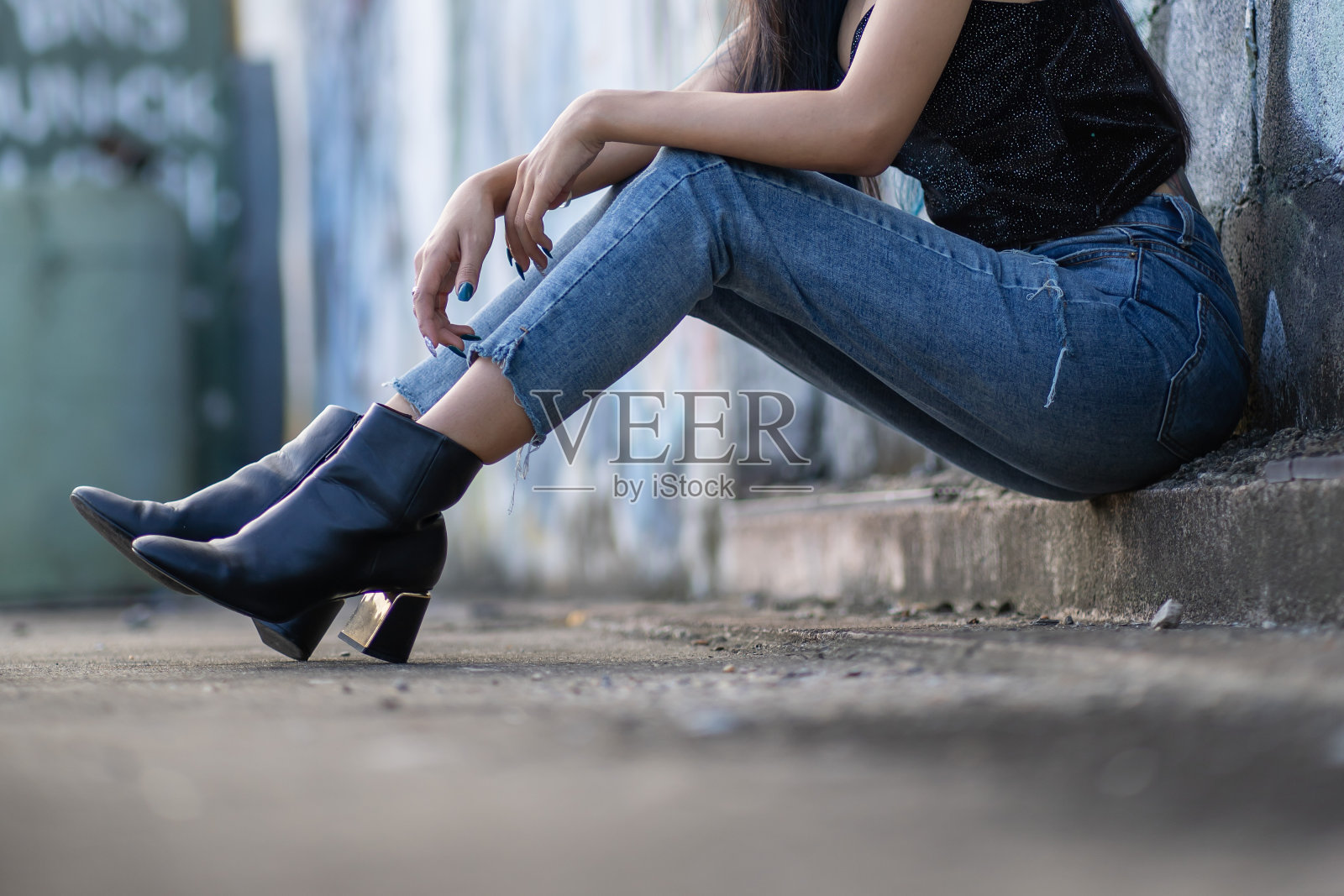 穿着牛仔裤和靴子的年轻女子照片摄影图片