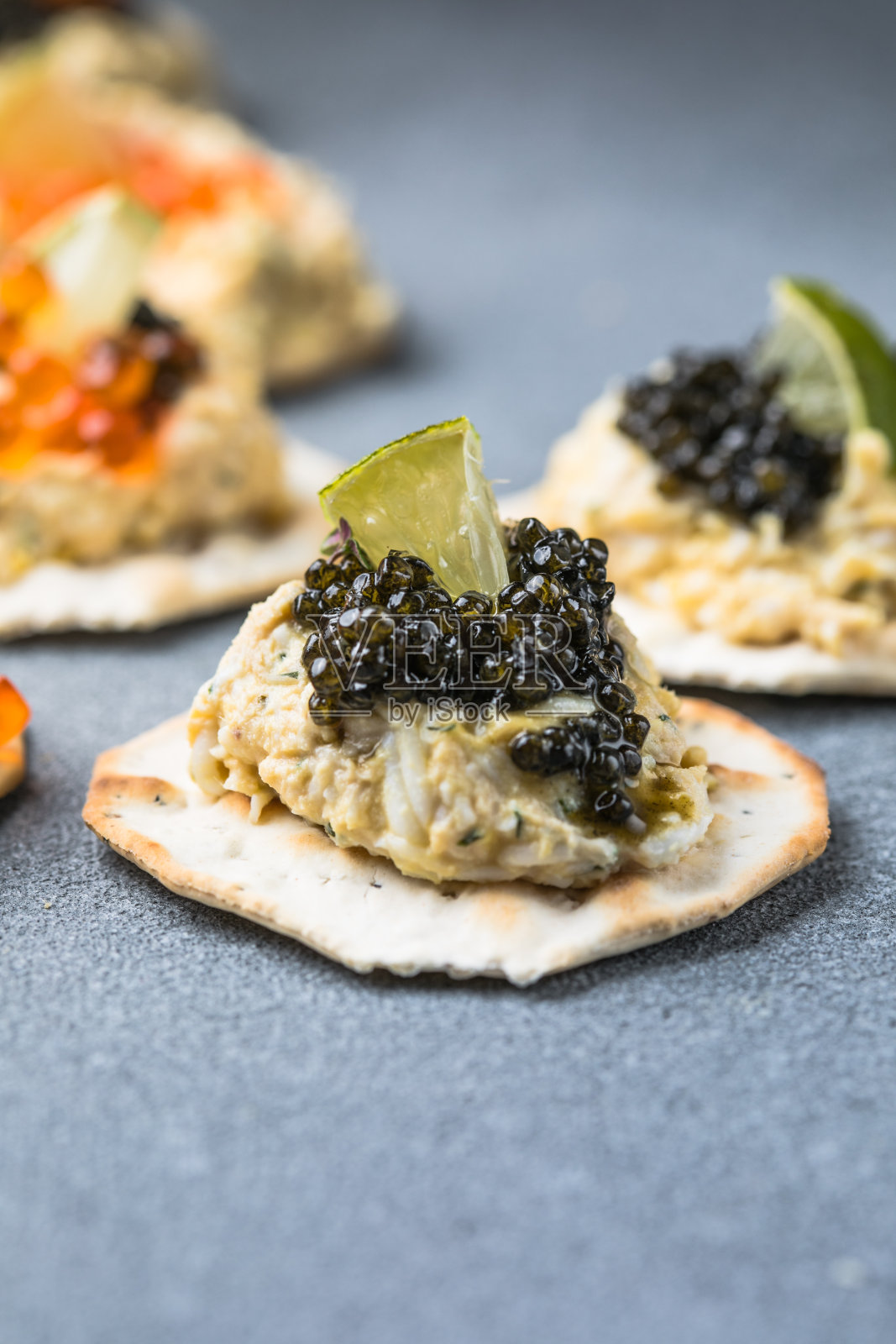 节日小点心用红色和黑色的鱼子酱,在鞭炮上喜庆的银色圣诞装饰,复制空间,精选焦点,景深窄照片摄影图片