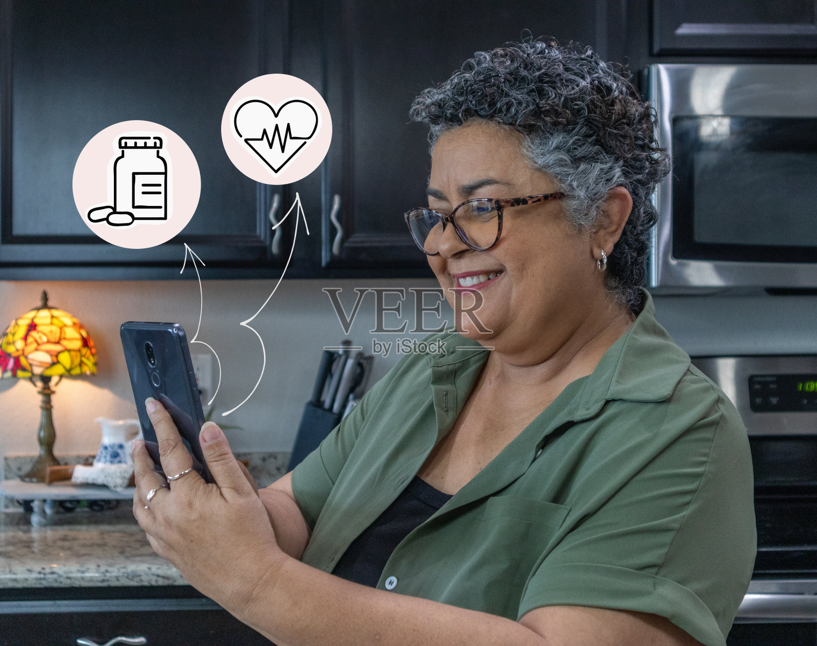 一名成熟的西班牙裔女性在智能手机上更新健康记录照片摄影图片