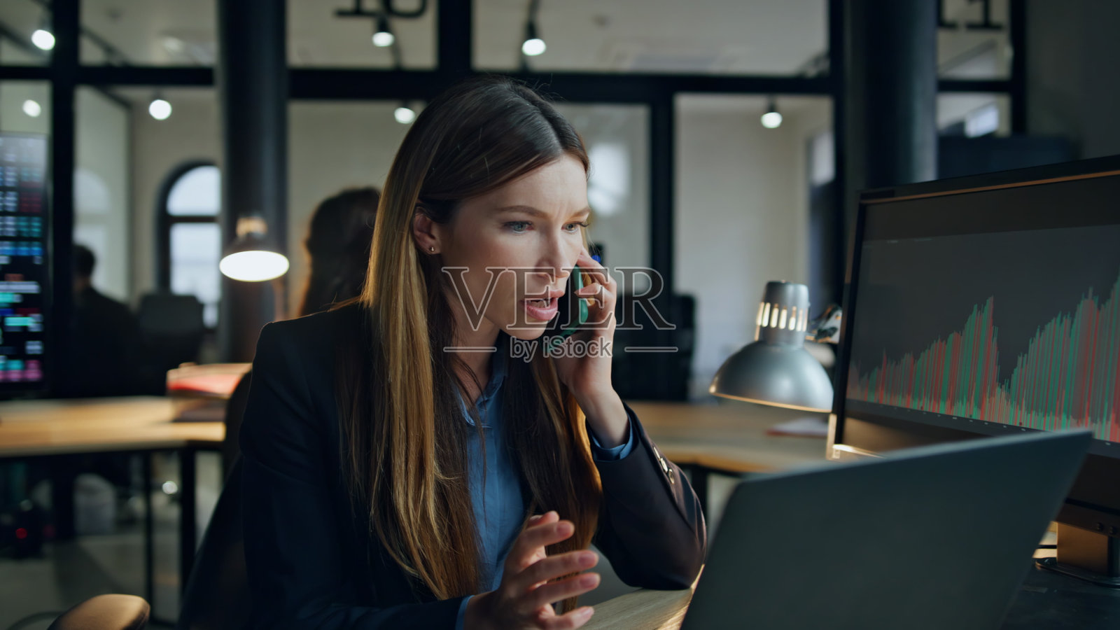 沮丧的经理在灯光下讲手机。沮丧的女商人工作照片摄影图片