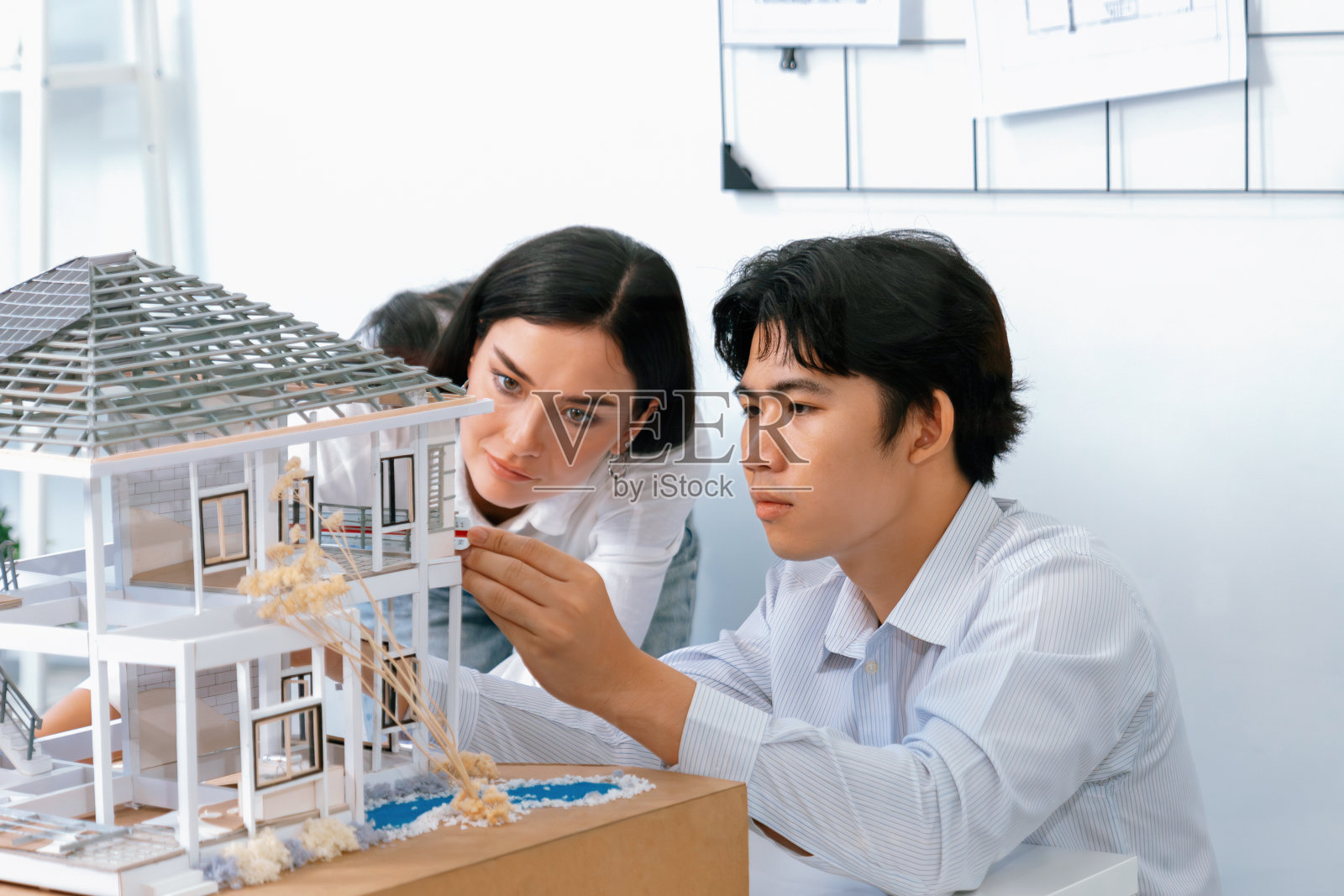 合作的工程师团队一起测量房屋模型。完美的. .照片摄影图片