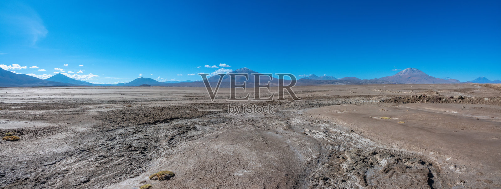 穿越智利边境附近的奇瓜纳盐沼沙漠。玻利维亚波托西,被雄伟的火山包围的贫瘠景观照片摄影图片