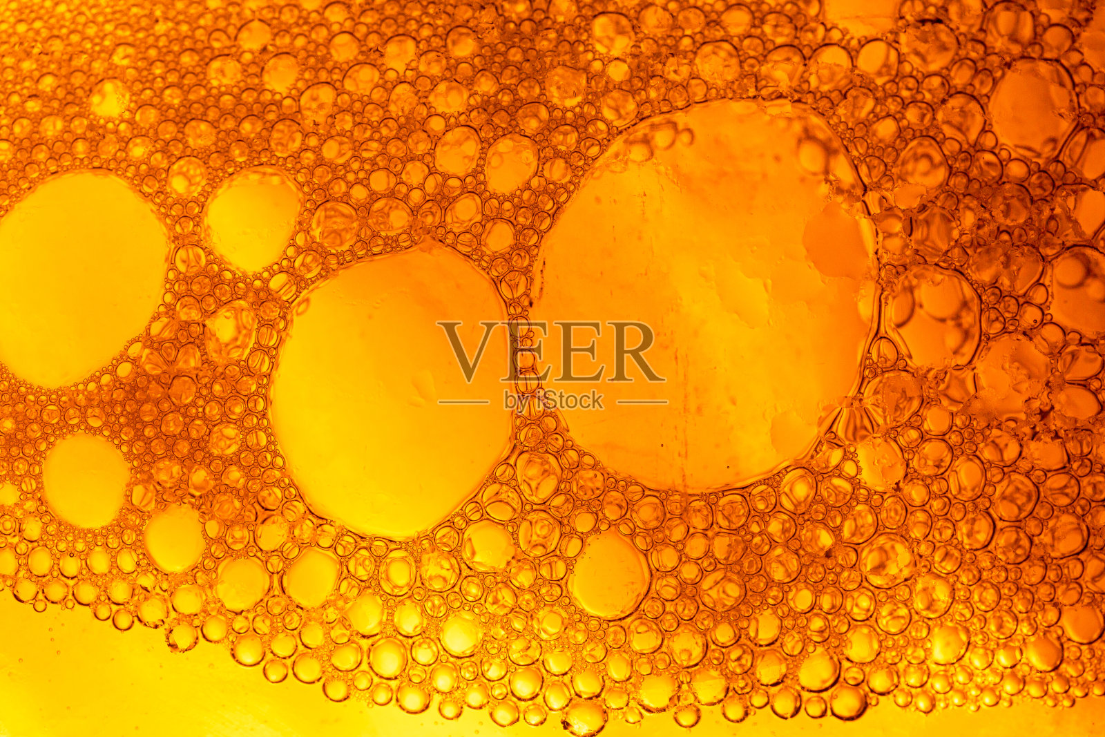 啤酒气泡表面,微距特写,冷却杯啤酒特写。啤酒杯冰冷的表面上有小水滴。照片摄影图片