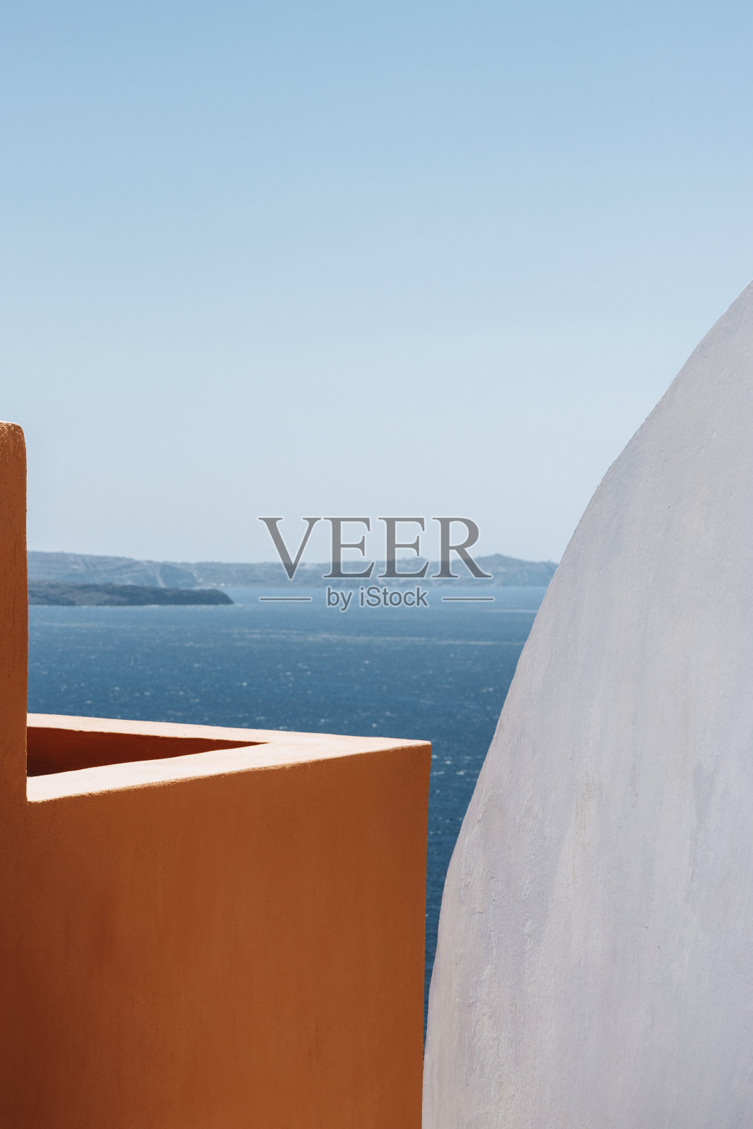 在希腊基克拉迪群岛的圣托里尼岛,橙色和白色的极简主义建筑俯瞰着爱琴海照片摄影图片