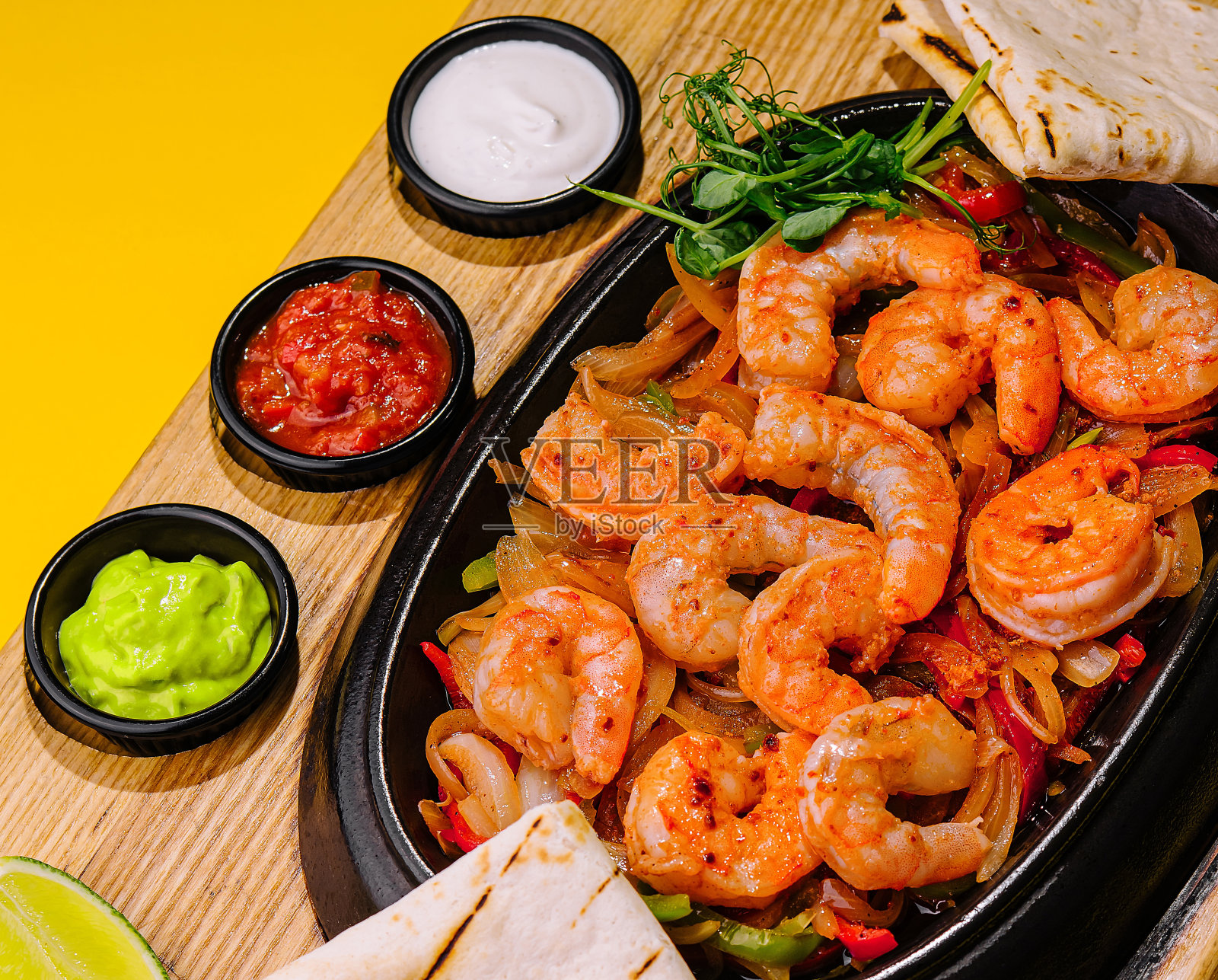 用煎锅将大虾与洋葱和辣椒一起煎照片摄影图片