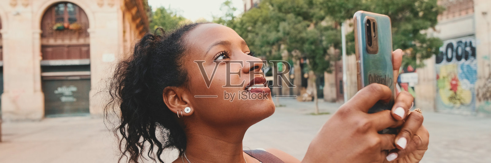 年轻的混血儿女子用手机,拍摄古城的全景照片照片摄影图片