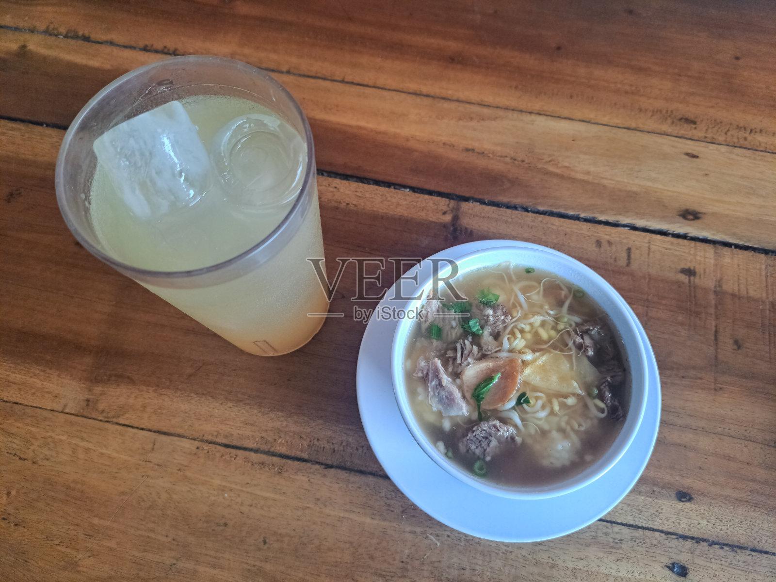 美味的索托大龄Sapi或传统牛肉汤。配上柠檬冰杯(Es Jeruk Di Gelas)。食物和饮料菜单。照片摄影图片