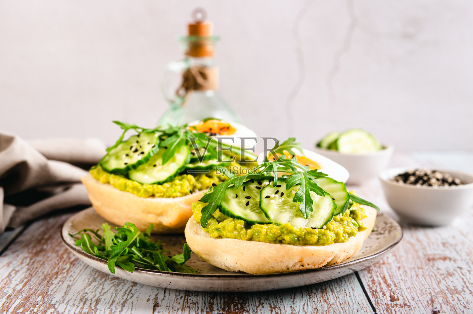 三明治加牛油果,黄瓜,鸡蛋和芝麻菜放在盘子里照片摄影图片