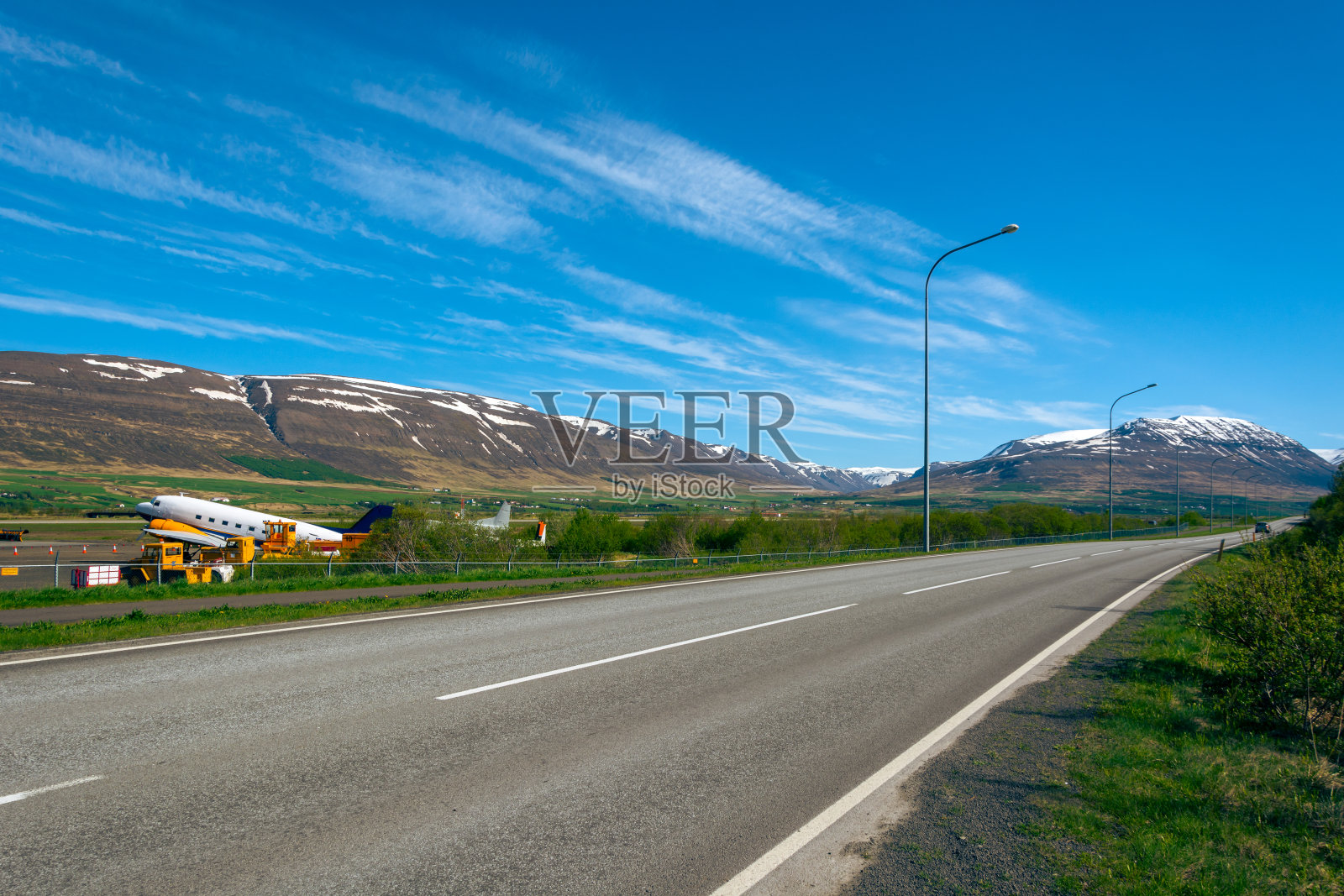 在一个晴朗的日子里,蓝蓝的天空中有云,冰岛山区的道路照片摄影图片
