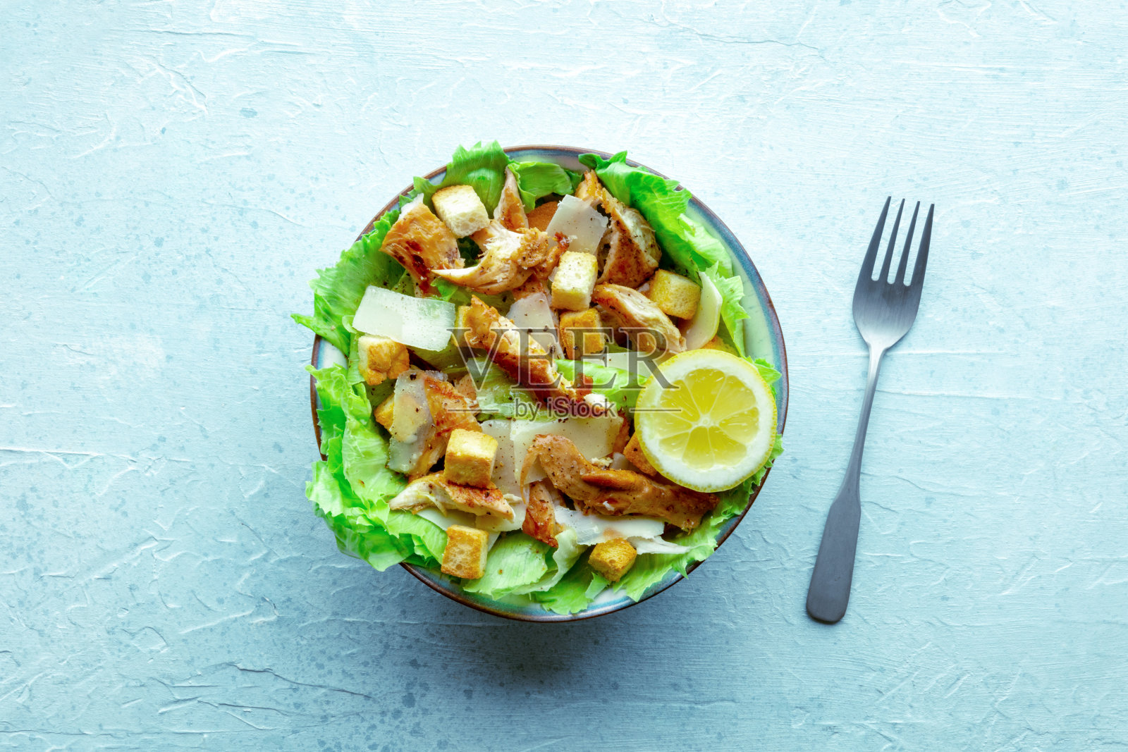 凯撒沙拉,有鸡胸肉、生菜、面包丁和柠檬照片摄影图片