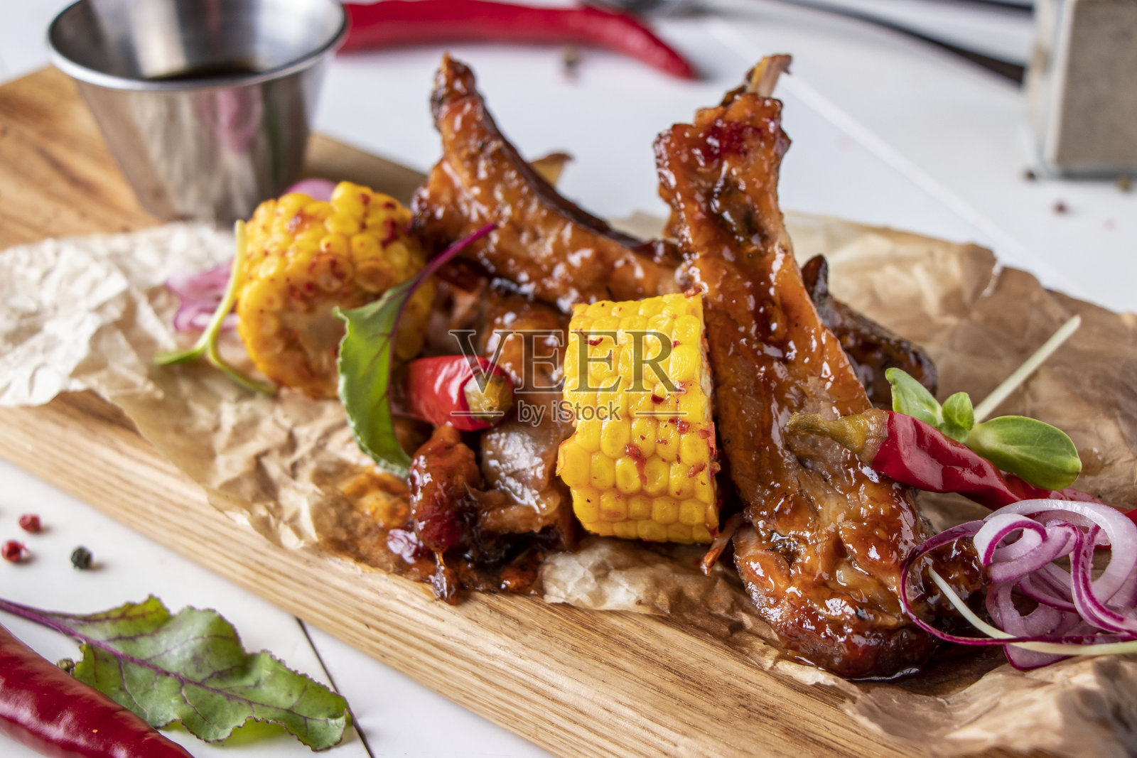 用酱油烤上釉的猪排,配上玉米,横置在木板上照片摄影图片