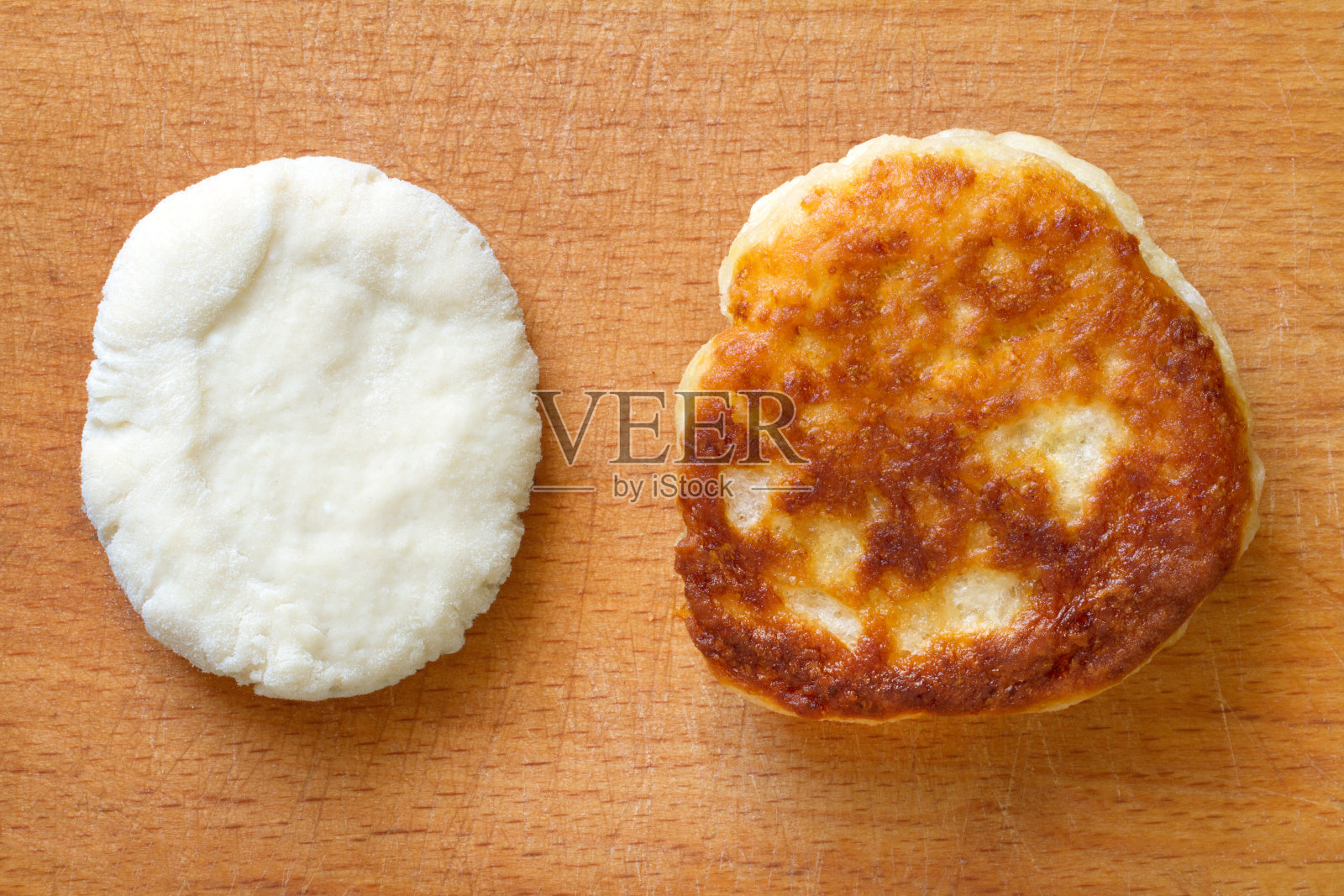 生的和煎过的煎饼放在木头表面上。照片摄影图片