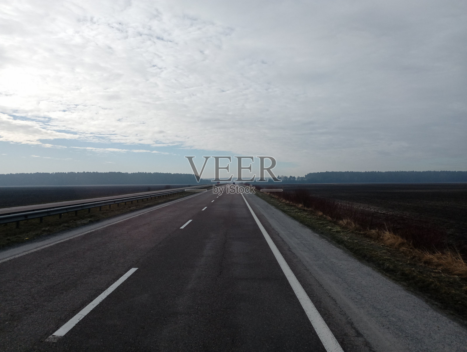 一条笔直向前的宽阔的柏油路。没有汽车的空旷公路。道路标记。照片摄影图片