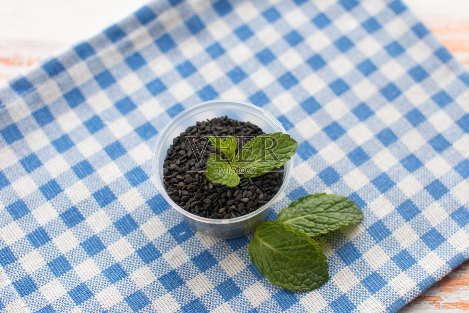 木背景碗里的芝麻。烹饪用调味品照片摄影图片