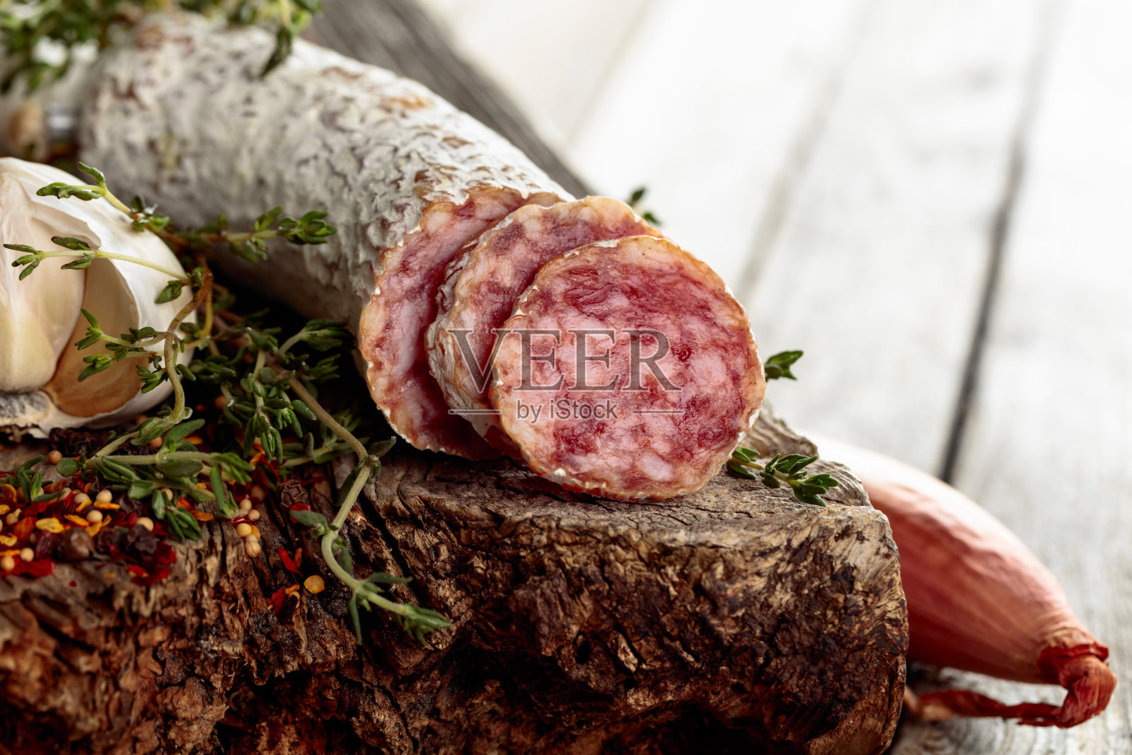 旧木桌上的干腊肠。照片摄影图片