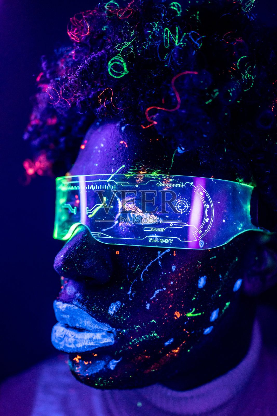 一个男人的肖像,涂上了紫外线的荧光色,戴着赛博眼镜照片摄影图片