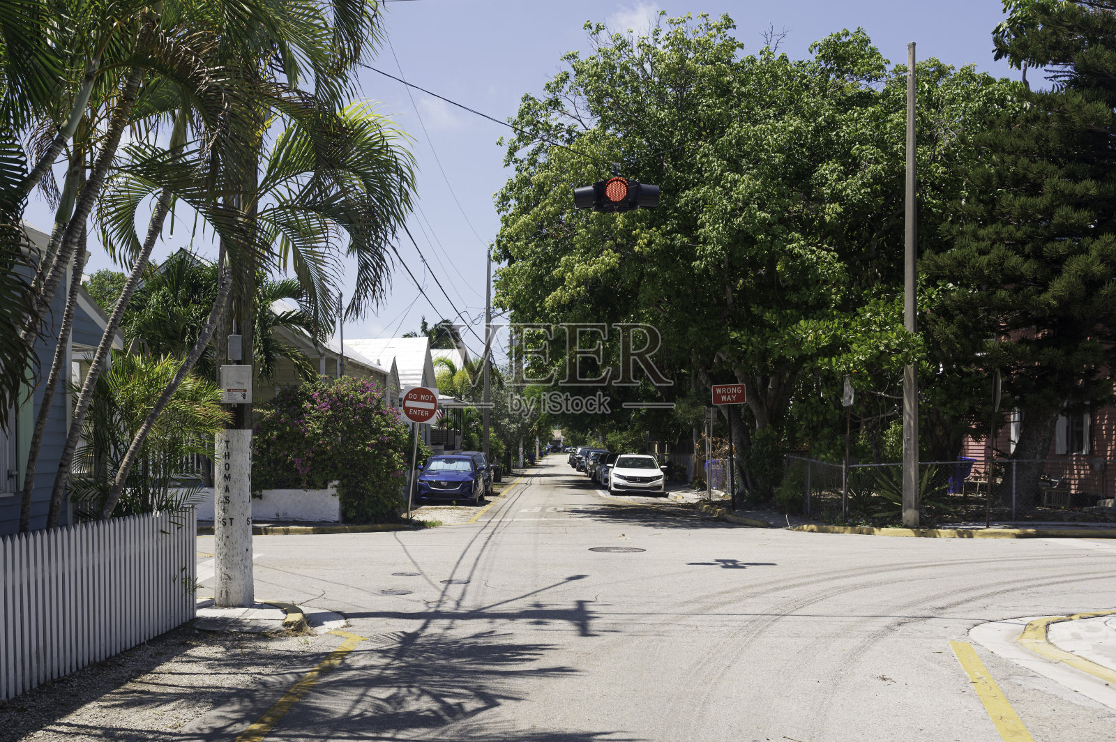 位于佛罗里达州基韦斯特的一条典型街道,道路上方有一个红色交通信号灯。天气晴朗照片摄影图片
