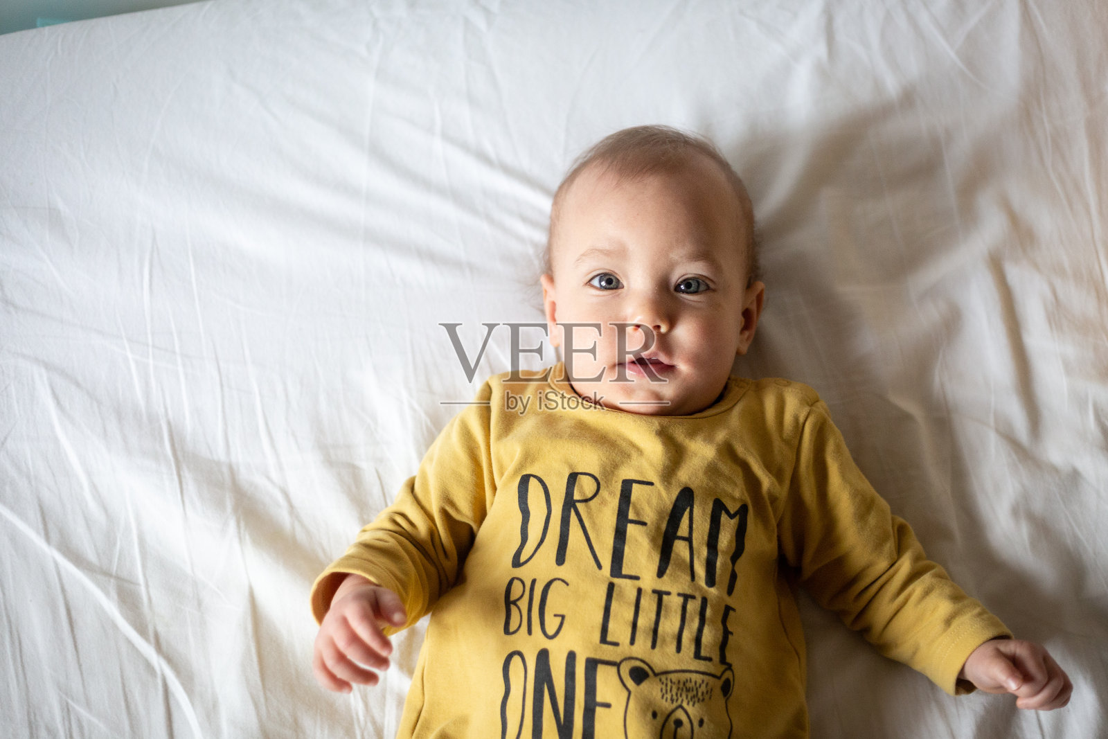 小婴儿躺在床上看镜头的上视图照片摄影图片