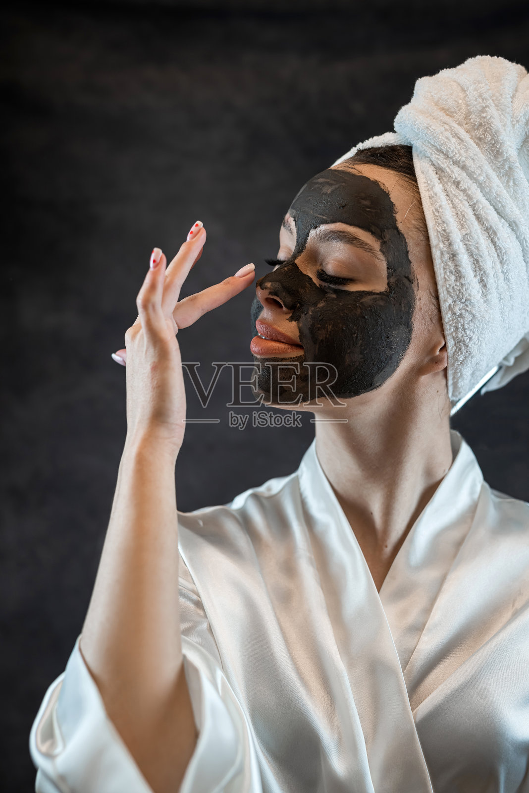 美丽的年轻女子与黑色粘土面具隔离在黑色照片摄影图片