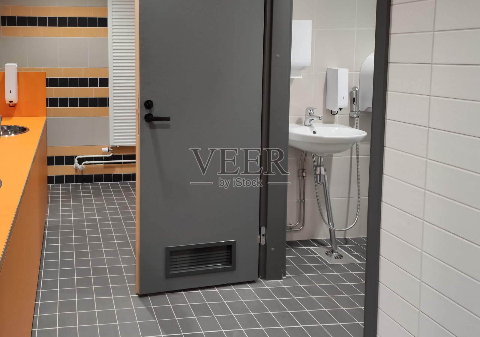 设有私人隔间的公共洗手间和洗手区。照片摄影图片