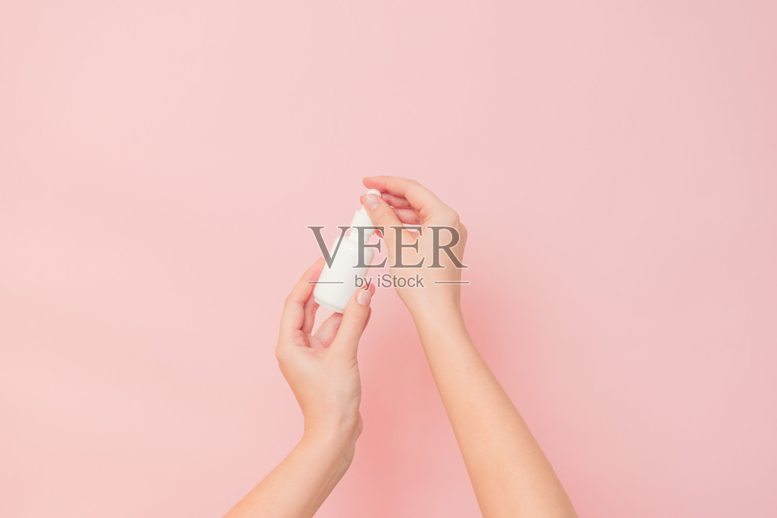 白色的瓶子里装着精华液或精油(透明质酸和胶原蛋白),底色为粉红色。护肤化妆品概念,美容传单照片摄影图片