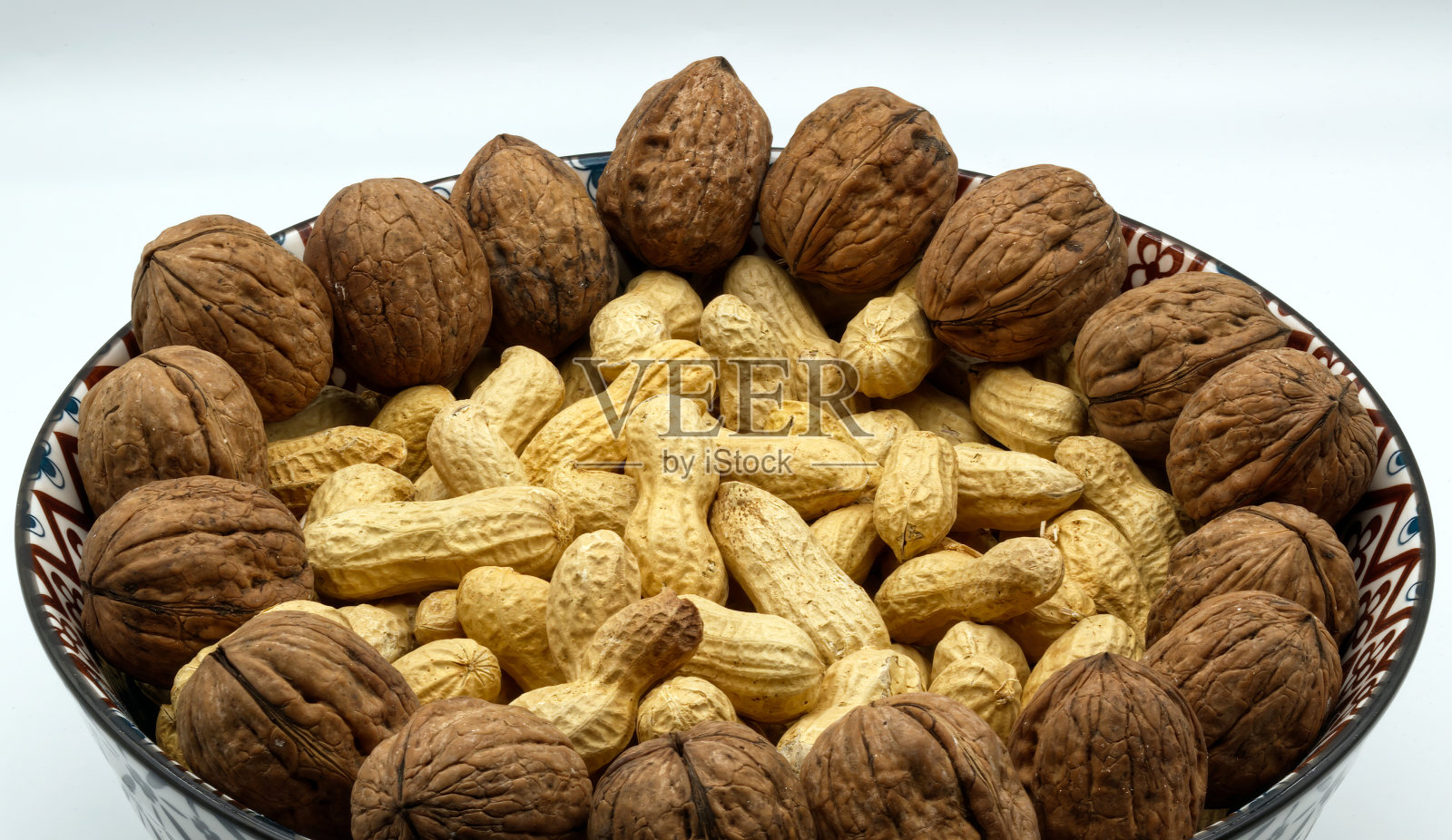 核桃和花生在一弓上隔白。照片摄影图片